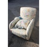 A 1930s armchair with shaped arms, upholstered in a floral and scroll glazed chintz