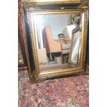 A rectangular wall mirror with bevelled plate and ebonised and gilt frame, 15" x 19"