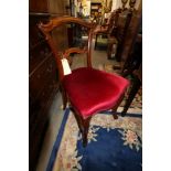 A set of six Victorian carved rosewood loop back standard dining chairs, upholstered in a crimson