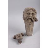 A Japanese carved rootwood bust of a bearded elder, 11" long, and another carved head, 4 1/2" long