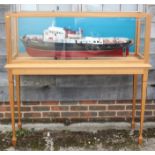 A scale model "Seabee" tug boat, 43" long x 9 1/2" wide approx, in light oak case, 53 3/4" wide x 17