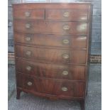 An early 19th century figured mahogany bowfront chest of two short and five graduated long drawers