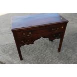An 18th century mahogany lowboy, fitted one long drawer over two short drawers and shaped apron,