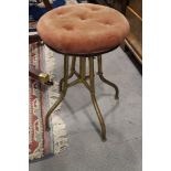 An early 20th century brass framed piano stool with adjustable seat
