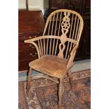 An ash and elm Windsor splat back elbow chair with panel seat and crinoline stretcher