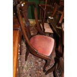 A set of four Edwardian walnut pierced shaped splat back dining chairs with drop-in seats, on