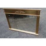 A gilt framed overmantel mirror with scroll decoration and reeded side panels, bevelled plate, 23" x