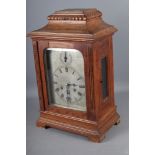 An oak cased bracket clock with chiming movement, silvered dial and Roman numerals, 18 1/2" high