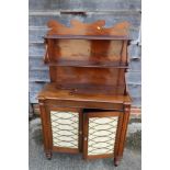 A Regency mahogany chiffonier, fitted two open shelves over fabric fronted cupboards, on turned