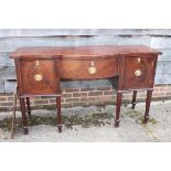 An early 19th century mahogany and rosewood banded serpentine front sideboard, fitted cellarette