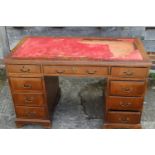 A walnut twin pedestal desk with nine drawers, on bracket supports and tooled red leather top (