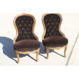 A pair of carved and polished as walnut showframe low-seat nursing chairs, button upholstered in a