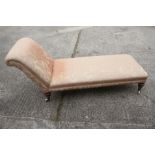 A late 19th century chaise longue, upholstered in a scroll brocade, on turned and castored supports,