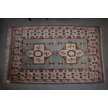 A Kazak rug with two white cruciform guls on a light blue ground and multi-borders in shades of