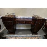 A Regency mahogany and ebony line inlaid inverse break bow drop centre sideboard with brass scroll