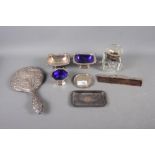 A silver hand mirror, decorated flowers, a silver mounted comb, a rectangular silver pin dish and