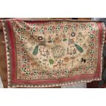 An Indian needlepoint wall hanging, decorated figures and animals with mirror embellishments, 38"