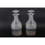 A pair of Georgian cut glass decanters with ribbed necks, 10 1/4" high (chips to stoppers and necks)