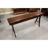 A late Victorian mahogany organ stool with panel seat, on splay supports, 54" wide x 11" deep x