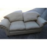 A two-seat settee with splay arms and down loose seat and back cushions, on turned supports and