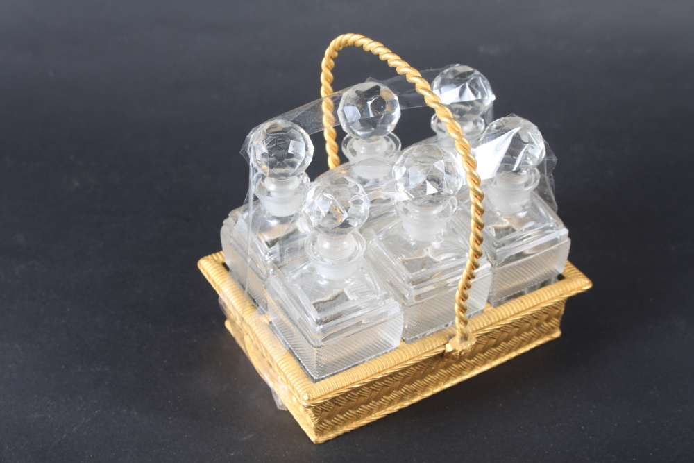 A 19th century Palais Royale type gilt metal basket, containing six cut glass scent bottles and - Image 2 of 4