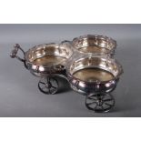 A silver plated three-bottle wine coaster, on wheels, 14" high