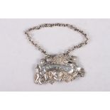 An early 19th century cast silver "Sauterne" decanter label / bottle ticket, decorated putti,