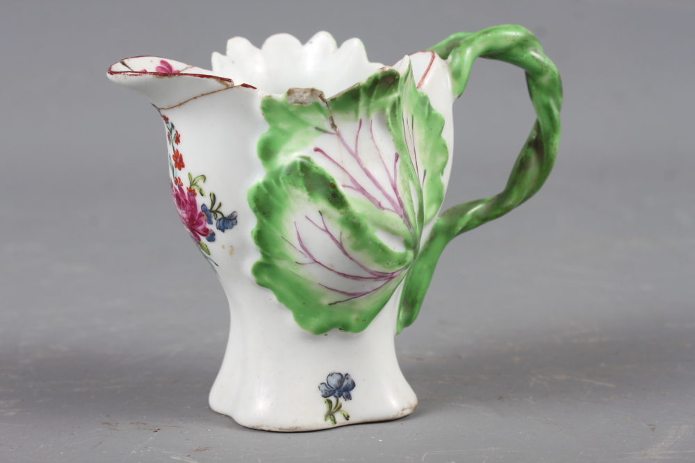 A Longton Hall cream jug with openwork twist handle and leaf relief decoration and enamel floral
