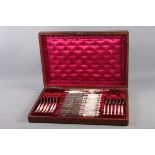 A set of twelve silver plated and engraved dessert knives and forks and matching servers, with