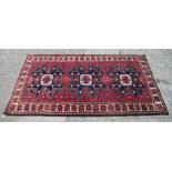 A Turkman rug with starburst design on a washed red ground, 76" x 42" approx