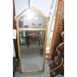 A gilt framed arch top wall mirror with bevelled plate, 39" x 17" overall