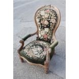 A 19th century carved and faded mahogany showframe open armchair with needlepoint seat and back