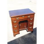 A Georgian mahogany kneehole writing desk with lift-up lid and fitted interior over six drawers