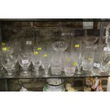 A quantity of cut glass pedestal glasses, including wines, brandies and liqueurs, a decanter and two