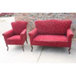 An Edwardian two-seat settee, upholstered in a red floral moquette, on cabriole supports, and a