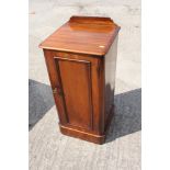 A late 19th century mahogany ledge back bedside cupboard enclosed panel door, on block base, 15"
