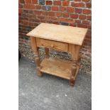 A waxed pine two-tier washstand, fitted drawer, on turned supports, 25" wide