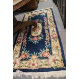 A Chinese contour pile rug with floral design on a blue ground, 75" x 37" approx