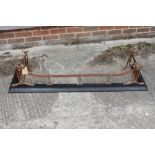 An Edwardian embossed copper "ribbon" fender curb, on cast iron base, 54" wide overall, and a