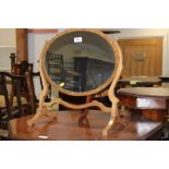 A polished as walnut skeleton framed oval swing mirror, plate 15 1/4" wide