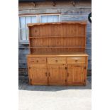 A pine dresser, fitted shelves over three drawers and cupboards, on block base, 66" wide x 16 1/2"