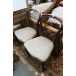 A pair of Victorian rosewood loop back dining chairs, upholstered in a cream fabric, on cabriole