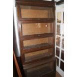 An oak five-sectional bookcase with glazed fall front doors and drawer to base, 25" wide x 16"