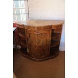 A late Victorian figured walnut shape front credenza with open shelves and panel bowfront door, on