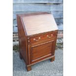 An Edwardian mahogany box and ebony strung fall front bureau, the fitted interior over one long