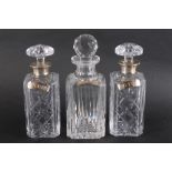 Two silver collared cut glass decanters, another cut glass decanter and three silver plated decanter
