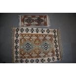 A Kazak kelim rug with two hooked guls on a tan ground, 50" x 34" approx, and a smaller similar rug,