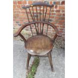 An Arts and Crafts spindle back elbow chair, on turned supports