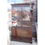 A 19th century mahogany bookcase, the upper section fitted adjustable shelves enclosed astragal