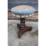 A Victorian rosewood piano stool with adjustable circular needlepoint seat, on spiral turned